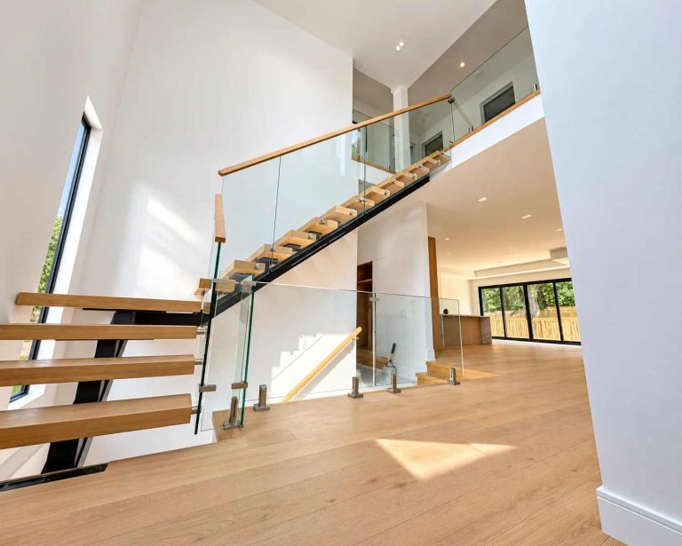 Floating Staircase With Clear Glass Railings And Wood Handrail